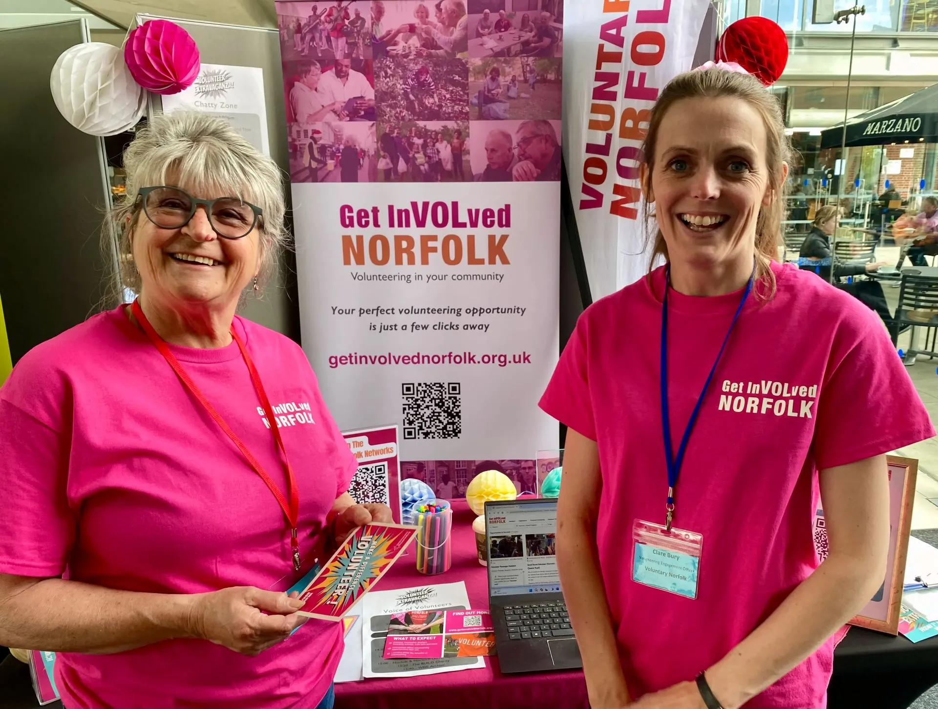 two people wearing Voluntary Norfolk shirts in front the GetInVOLved stall
