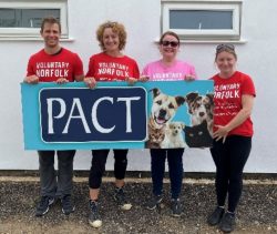 volunteers holding PACT charity sign