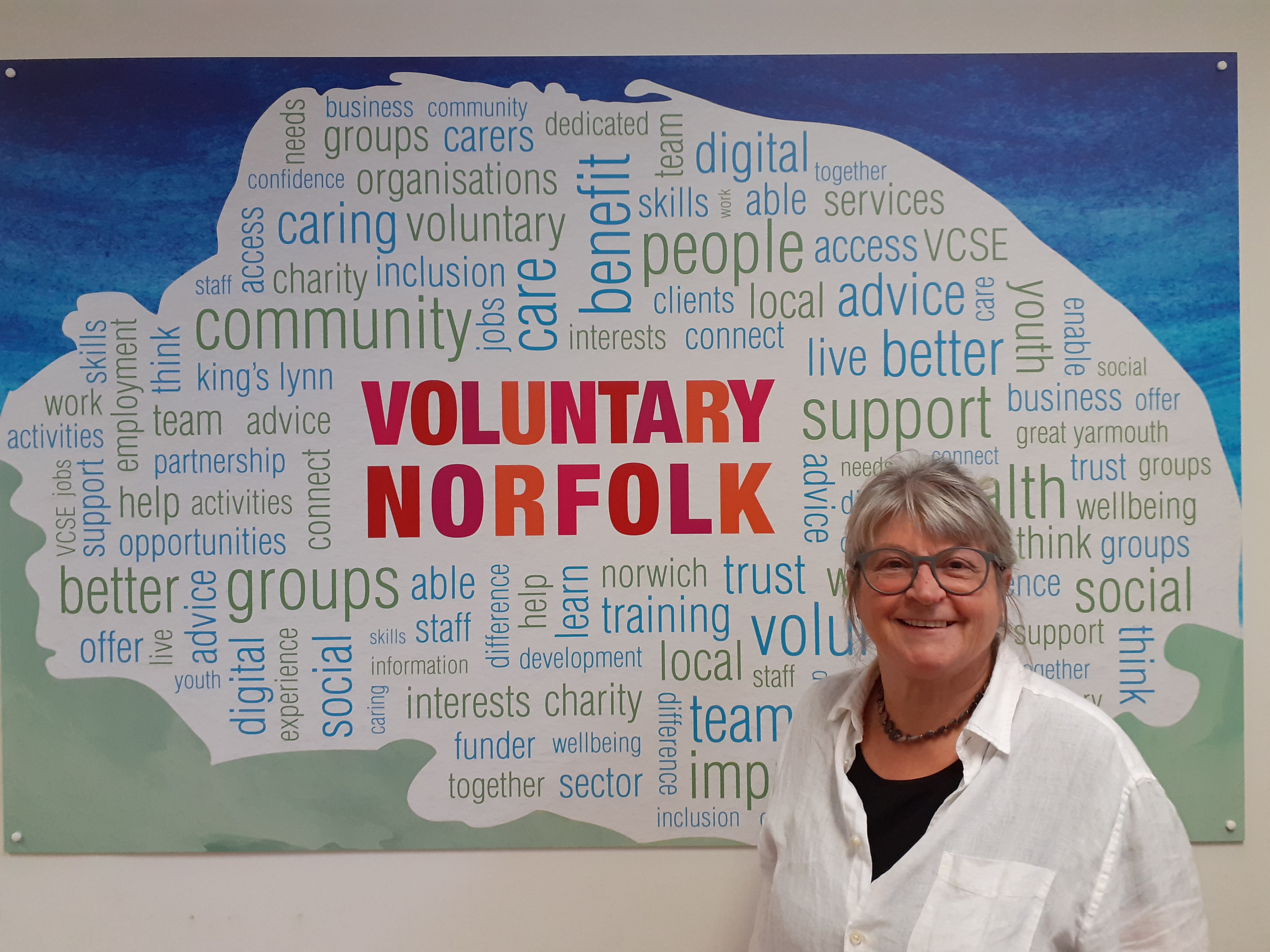 Person standing in front of Voluntary Norfolk Sign